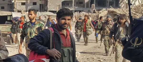 Syrian soldiers, and pro-government forces, are seen in front of damaged buildings in the eastern Syrian city of Deir Ezzor on November 3, 2017 - Sputnik International