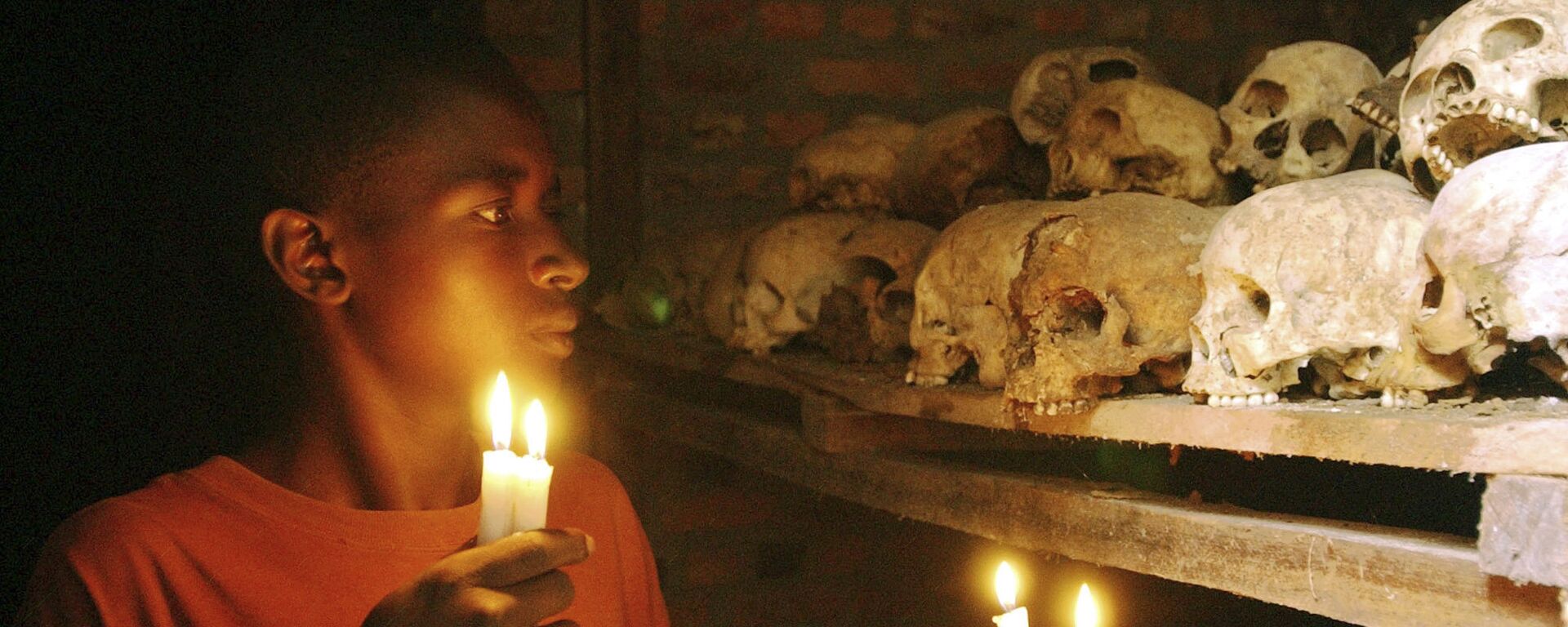 FILE - In this April 6, 2004 file photo, Apollan Odetta, a survivor from the 1994 Rwandan Genocide light candles at a mass grave in Nyamata, Rwanda - Sputnik International, 1920, 07.04.2020