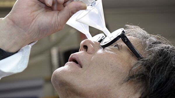 Kenji Kawakami, inventor and founder of the International Chindogu Society demonstrates his funnel glasses designed to guide eyedrops so that they never miss their mark in Tokyo on June 3, 2009 - Sputnik International