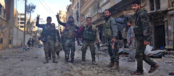Syrian soldiers, and pro-government forces, pose for a picture in front of damaged buildings in the eastern Syrian city of Deir Ezzor on November 3, 2017 - Sputnik International