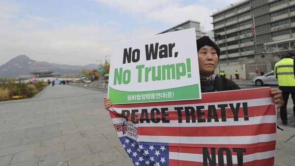A South Korean woman holds banner during an anti-war rally ahead of U.S. President Donald Trump's visit to the country near U.S. Embassy in Seoul, South Korea, Monday, Nov. 6, 2017 - Sputnik International
