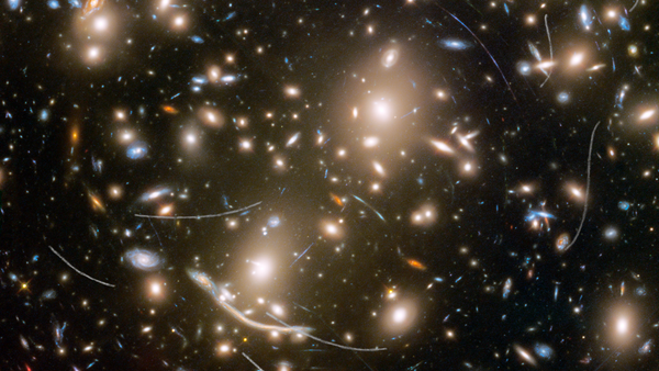 Galaxy cluster Abell 370 contains several hundred galaxies locked together by gravitational pull. It is located approximately 4 billion light-years away in the constellation Cetus, the Sea Monster. The thin, white trails that look like curved or S-shaped streaks are from asteroids that reside, on average, only about 160 million miles from Earth. - Sputnik International