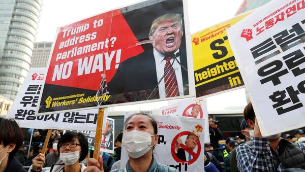 Protesters against U.S. President Donald Trump hold placards while waiting for Trump's motorcade to pass by in central Seoul, South Korea, November 7, 2017 - Sputnik International