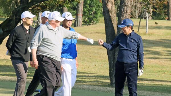 U.S. President Donald Trump gestures to Japan's Prime Minister Shinzo Abe as Japanese professional golfer Hideki Matsuyama looks on, as they play golf at the Kasumigaseki Country Club in Kawagoe, north of Tokyo, Japan, in this photo taken and released by Japan's Cabinet Public Relations Office via Kyodo November 5, 2017 - Sputnik International