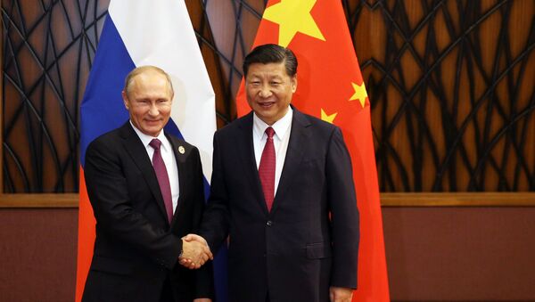 Russian President Vladimir Putin and Chinese President Xi Jinping shake hands during a meeting on the sidelines of the APEC summit in Danang, Vietnam - Sputnik International