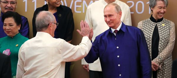 Russian President Vladimir Putin poses for a family photo in traditional Vietnamese clothes during the APEC Economic Leaders’ Meeting in Vietnam - Sputnik International