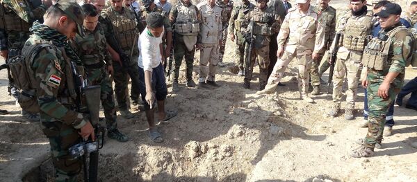 Iraqi forces search the site of a suspected mass grave containing the remains of victims of the Islamic State group, near the former al bakara military base on November 11, 2017, south west of Hawija - Sputnik International