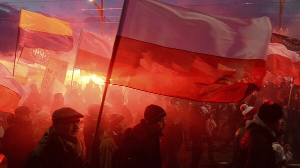 Demonstrators burn flares and wave Polish flags during the annual march to commemorate Poland's National Independence Day in Warsaw, Saturday, Nov. 11, 2017. Thousands of nationalists marched in Warsaw on Poland's Independence Day holiday, taking part in an event that was organized by far-right groups - Sputnik International