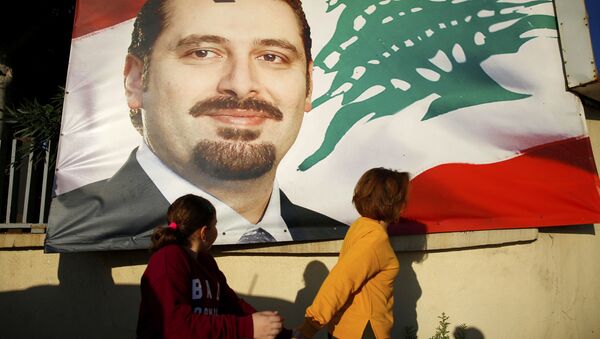 A woman and her daughter pass by a poster of outgoing Prime Minister Saad Hariri, in Beirut, Lebanon, Saturday, Nov. 11, 2017. Lebanon's president has called on Saudi Arabia to clarify the reasons why the country's prime minister has not returned home since his resignation which was announced from the kingdom - Sputnik International