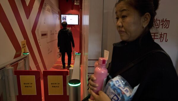 A woman waits to leave a Unmanned Convenience Store that uses facial recognition to allow shoppers to walk in and pay for their purchases without having to go through a human cashier at the headquarters forChinese e-commerce giant JD.com in Beijing, China, Saturday, Nov. 11, 2017. Chinese consumers are spending billions of dollars shopping online for anything from diapers to diamonds on Singles Day, a day of promotions that has grown into the world's biggest e-commerce event. - Sputnik International