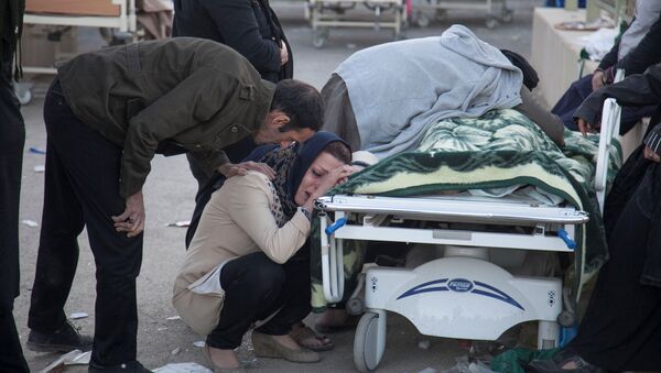 A woman reacts next to a dead body following an earthquake in Sarpol-e Zahab county in Kermanshah, Iran November 13, 2017 - Sputnik International