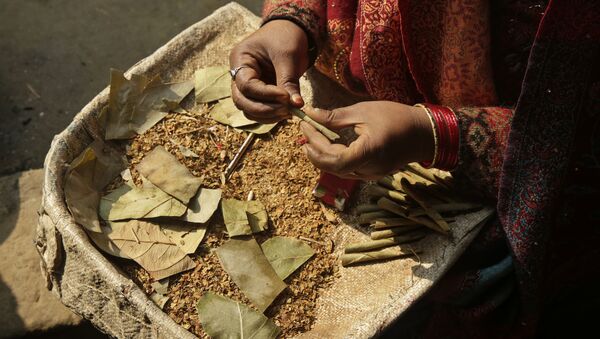 An Indian woman rolls bidis, or shredded tobacco hand-rolled, at a cottage industry on the outskirts of Allahabad, India, Tuesday, Jan. 17, 2017 - Sputnik International