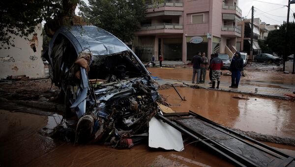 A destroyed car is seen next to a flooded street following heavy rainfall in the town of Mandra, Greece, November 15, 2017 - Sputnik International