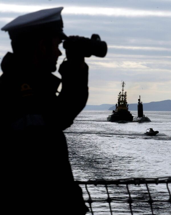 British Royal Naval Officer Paul Matthews, left, onboard the British frigate HMS Montrose watches as a tug boat tows the Canadian submarine HMCS Chicountimi up the River Clyde towards the British Naval Base at Faslane, Scotland. - Sputnik International