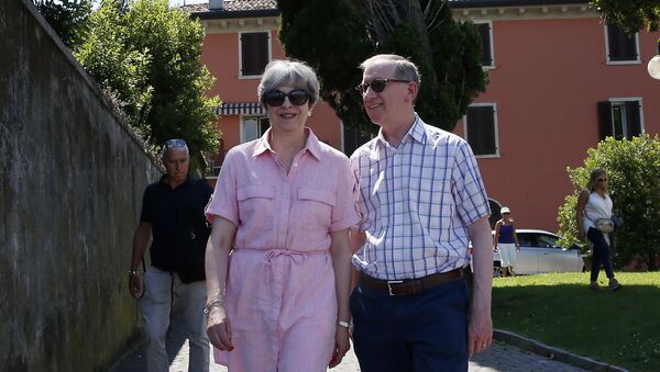 Britain Prime Minister Theresa May, left, walks with her husband Philip as they visit Desenzano del Garda, by the Garda lake, northern Italy, Tuesday, July 25, 2017. May is spending her holidays in northern Italy. - Sputnik International