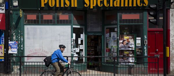 A man as he cycles past a Polish Specialties shop in London. - Sputnik International