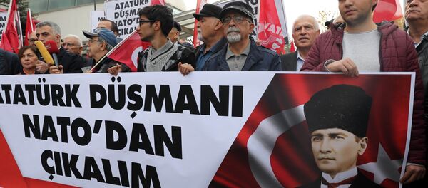 Protestors wave flags and carry a banner during a demonstration against NATO military exercises on November 18, 2017 in Ankara - Sputnik International