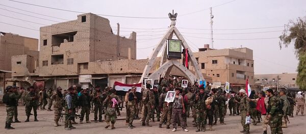 Members of the pro-Syrian government forces pose with portraits of Syrian President Bashar al-Assad and his late father Hafez al-Assad as they gather in a public square in the Syrian border town of Albu Kamal, on November 20, 2017 - Sputnik International