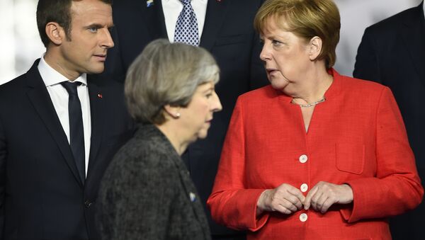 Britain's Prime Minister Theresa May, foreground walks by French President Emmanuel Macron, left, and German Chancellor Angela Merkel as they gather with NATO member leaders to pose for a group photo, prior to the start of their summit in Brussels, Belgium, Thursday, May 25, 2017. - Sputnik International