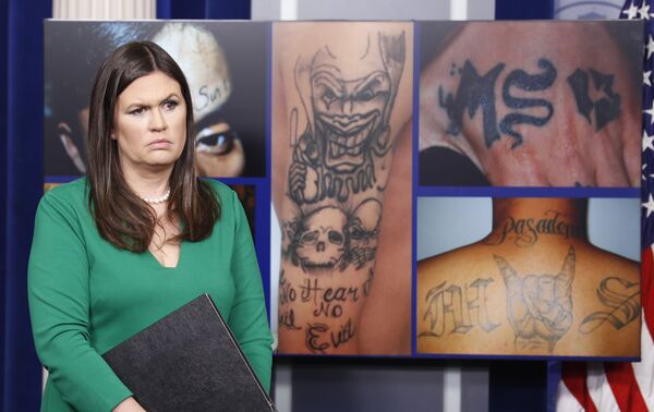 White House press secretary Sarah Huckabee Sanders stands in front of pictures of MS-13 gang tattoos during a press briefing at the White House in Washington, Thursday, July 27, 2017. White House press secretary Sarah Huckabee Sanders stands in front of pictures of MS-13 gang tattoos during a press briefing at the White House in Washington, Thursday, July 27, 2017. - Sputnik International