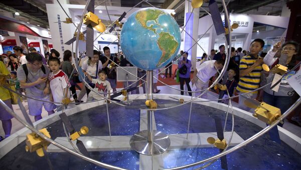 Visitors look at a mockup of China's homegrown Beidou satellite navigation system at the China Beijing International High-Tech Expo in Beijing, Saturday, June 10, 2017 - Sputnik International