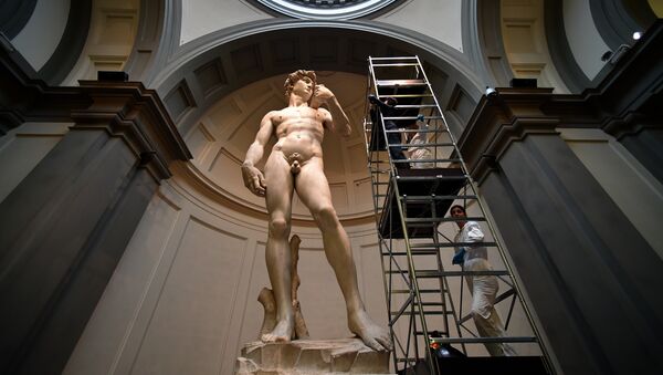 A person takes a photo of Michelangelo's David, one of the world's most famous statues, after cleaning by Italian restorers from the friends of Florence association on February 29, 2016 at the Galleria dell'Accademia in Florence, where the statue has been kept since 1873 - Sputnik International