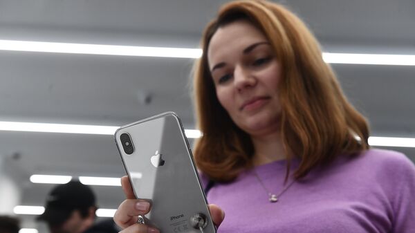 A buyer examines a new smartphone iPhone X in re:Store mobile equipment store on Tverskaya Street in Moscow - Sputnik International
