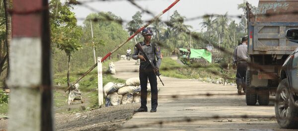 A Myanmar police officer stands watch as journalists arrive in Shwe Zar village in the suburb of Maungdaw town, northern Rakhine state of Myanmar, on Wednesday, Sept. 6, 2017 - Sputnik International