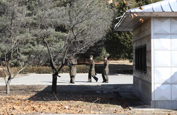 Three North Korean soldiers look at the South side at the spot where a North Korean soldier crossed the border at the Panmunjom in the Demilitarized Zone, South Korea Three North Korean soldiers look at the South side at the spot where a North Korean soldier crossed the border at the Panmunjom in the Demilitarized Zone, South Korea - Sputnik International