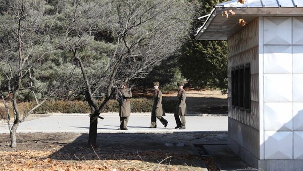 Three North Korean soldiers look at the South side at the spot where a North Korean soldier crossed the border at the Panmunjom in the Demilitarized Zone, South Korea - Sputnik International