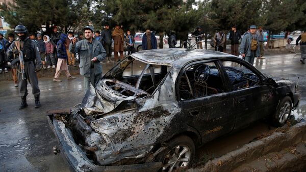 People look on at a damaged vehicle after a suicide bomb attack in Kabul, Afghanistan November 16, 2017 - Sputnik International