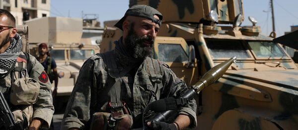 A fighter of the Syrian Democratic Forces (SDF) carries a weapon as he stands near a military vehicle in Raqqa, Syria, October 16, 2017 - Sputnik International