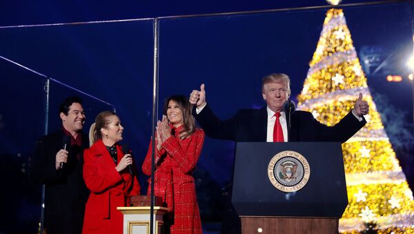 U.S. first lady Melania Trump, with U.S. President Donald Trump and hosts Dean Cain (L) and Kathie Lee Gifford (2nd L), reacts after she pressed the button to light the tree during the National Christmas Tree lighting ceremony near the White House in Washington, U.S. November 30, 2017 - Sputnik International