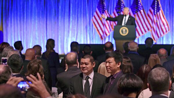 People in the audience have their photo taken as President Donald Trump speaks at a fundraiser - Sputnik International
