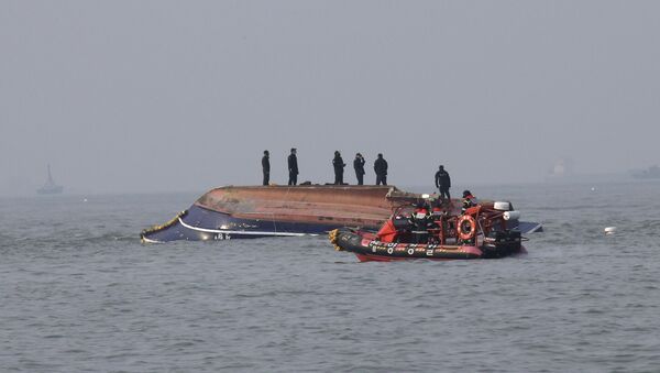 In this photo provided by South Korea's Ongjin County, South Korean Coast Guard officers try to rescue a capsized fishing boat which collided with a refueling vessel in the waters off Incheon, South Korea, Sunday, Dec. 3, 2017 - Sputnik International