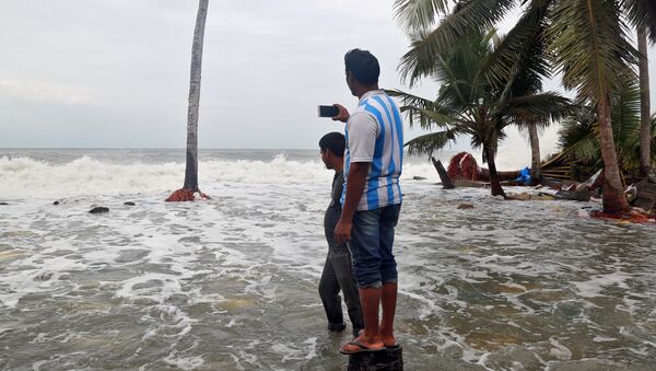 A man uses his mobile phone to take photographs of tides on the shores of the Arabian Sea, after flooding caused by Cyclone Ockhi in the coastal village of Chellanam in the southern state of Kerala, India, December 2, 2017 - Sputnik International