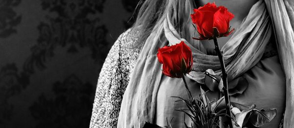 A young woman holding a rose A young woman holding a rose - Sputnik International