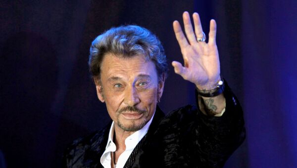 French singer Johnny Hallyday waves to fans attending a ceremony to promote his new album Jamais seul (Never alone) at the Virgin Megastore in Paris early March 28, 2011 - Sputnik International