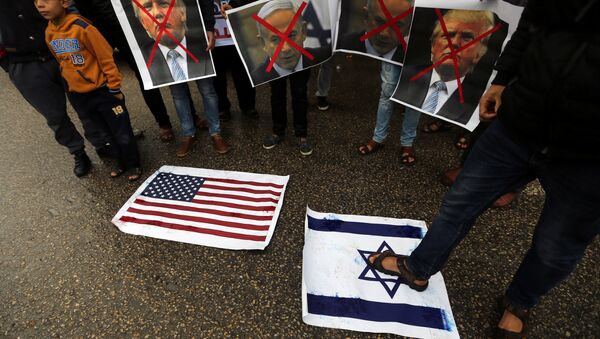 A Palestinian man steps on a representation of an Israeli flag as other demonstrators hold crossed out posters of US President Donald Trump and Israeli Prime Minister Benjamin Netanyahu during a protest against the U.S. intention to move its embassy to Jerusalem and to recognize the city of Jerusalem as the capital of Israel, in Rafah in the southern Gaza Strip December 6, 2017. - Sputnik International