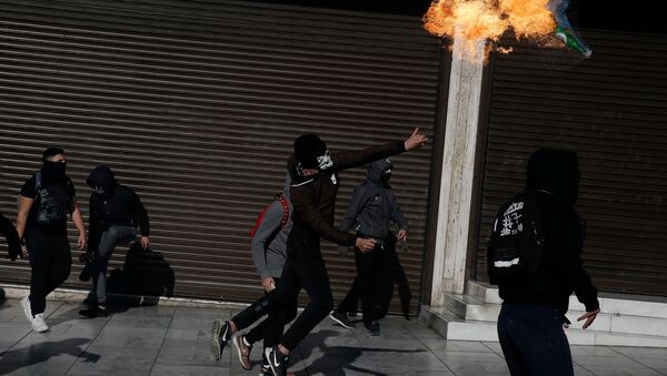 A hooded youth throws a petrol bomb to riot police during an anniversary rally marking the 2008 police shooting of 15-year-old student Alexandros Grigoropoulos, in Athens, Greece - Sputnik International