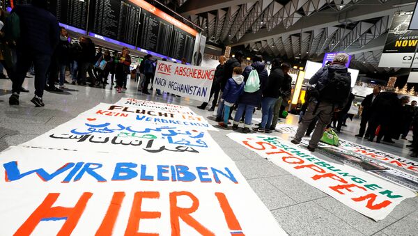 Protestors display placards reading We stay here, No deportation to Afghanistan and Fleeing is not a crime as they demonstrate against the deportation of people to Afghanistan at Fraport airport in Frankfurt, Germany, December 6, 2017 - Sputnik International