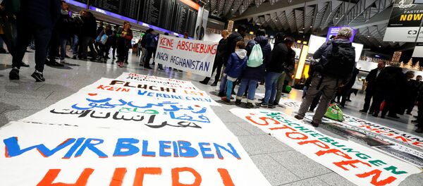 Protestors display placards reading We stay here, No deportation to Afghanistan and Fleeing is not a crime as they demonstrate against the deportation of people to Afghanistan at Fraport airport in Frankfurt, Germany, December 6, 2017 - Sputnik International