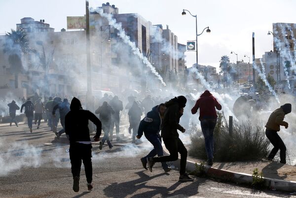 Palestinian protesters run from tear gas fired by Israeli troops during clashes at a protest against U.S. President Donald Trump's decision to recognize Jerusalem as the capital of Israel, near the Jewish settlement of Beit El, near the West Bank city of Ramallah December 7, 2017 - Sputnik International