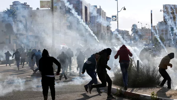 Palestinian protesters run from tear gas fired by Israeli troops during clashes at a protest against U.S. President Donald Trump's decision to recognize Jerusalem as the capital of Israel, near the Jewish settlement of Beit El, near the West Bank city of Ramallah December 7, 2017 - Sputnik International
