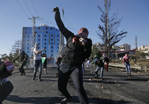 Palestinian protesters clash with Israeli troops near an Israeli checkpoint in the West Bank city of Ramallah on December 8, 2017 - Sputnik International
