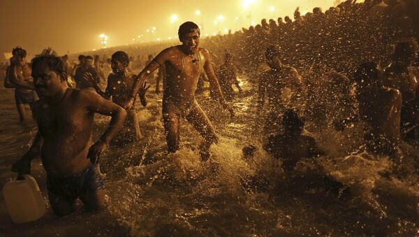 In this Jan. 14, 2013 file photo, an Indian Hindu man jumps up and down in the water as he takes a dip at Sangam, the confluence of the Ganges, Yamuna and mythical Saraswati River, during the royal bath on Makar Sankranti at the start of the Maha Kumbh Mela in Allahabad, India - Sputnik International