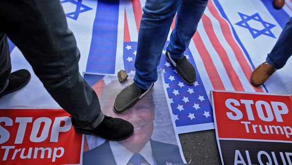 Palestinian protesters step on US and Israeli flags and on a portrait of US President Donald Trump following his decision to recognise Jerusalem as the capital of Israel, in Gaza City - Sputnik International