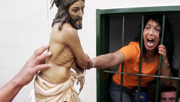 A prisoner tries to touch the statue of 'Jesus atado en la columna' (Jesus Tied To A Column) brotherhood during a holy week procession inside the Picasent prison, near Valencia, eastern Spain - Sputnik International