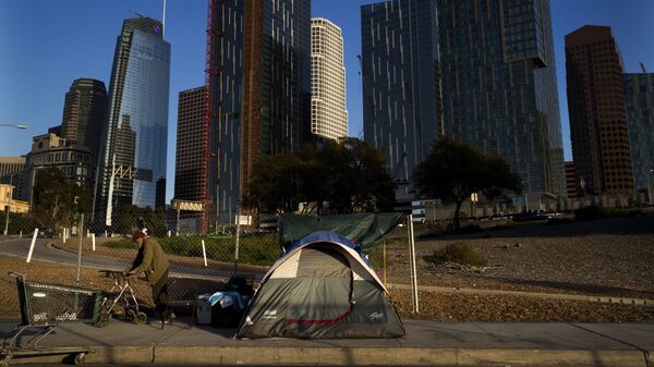 A homeless man, who declined to give his name, is dwarfed by skyscrapers Monday, Dec. 4, 2017, in Los Angeles. The U.S. Department on Housing and Urban Development release of the 2017 homeless numbers are expected to show a dramatic increase in the number of people lacking shelter along the West Coast. - Sputnik International