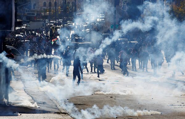 Palestinian demonstrators react to tear gas fired by Israeli troops during clashes at a protest against U.S. President Donald Trump's decision to recognize Jerusalem as the capital of Israel, in the West Bank city of Bethlehem December 9, 2017 - Sputnik International